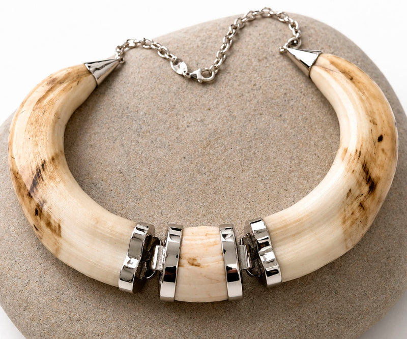 Collar facochero natural con centro de movimiento en plata de ley sobre piedra gris, joyería cinegética artesanal hecha a mano en Madrid