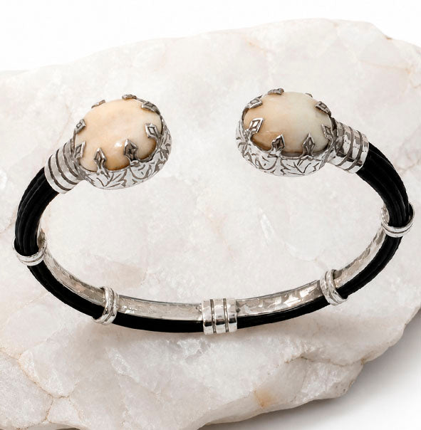 Detalle de perlas de venado enfrentadas en pulsera abierta con plata de ley y pelo de búfalo africano