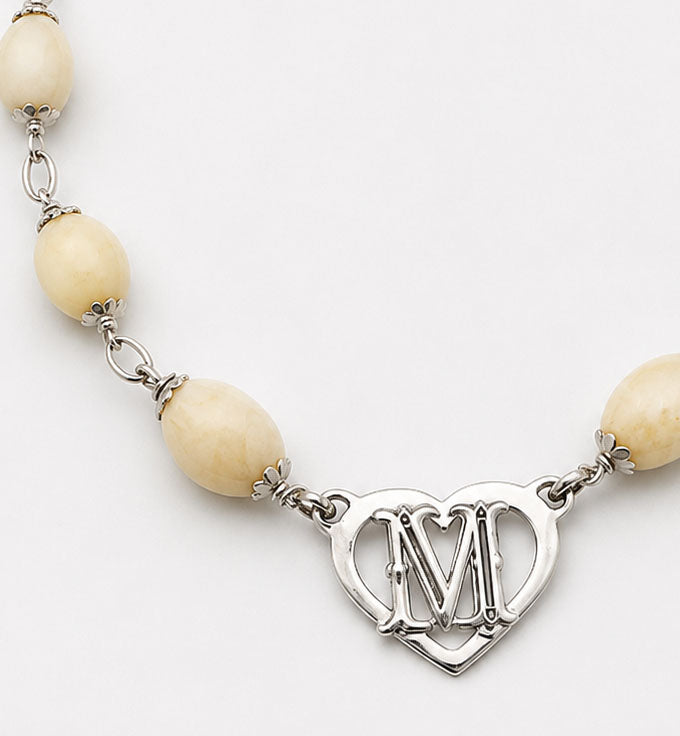 detalle del collar perla venado con corazon en plata con letra centro