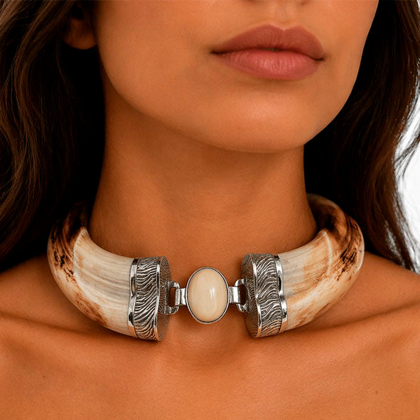 Collar artesanal de facochero con detalle central ovalado en plata y textura de piel de cebra en el cuello de la modelo