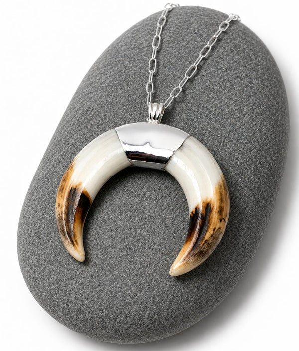 Detalle colgante luna en plata 925 sobre colmillo de facochero natural – joyería cinegética