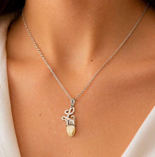 collar letra perla venado en el cuello de una mujer