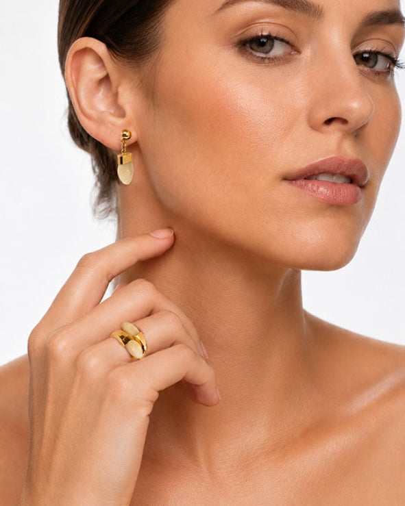 Modelo con pendientes colgando y anillo de perla de venado en oro amarillo de 18 quilates