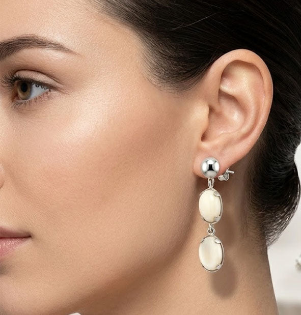 Pendientes Largos Doble Perla de Venado Oval en Plata de Ley detalle de los pendientes en la oreja de la modelo