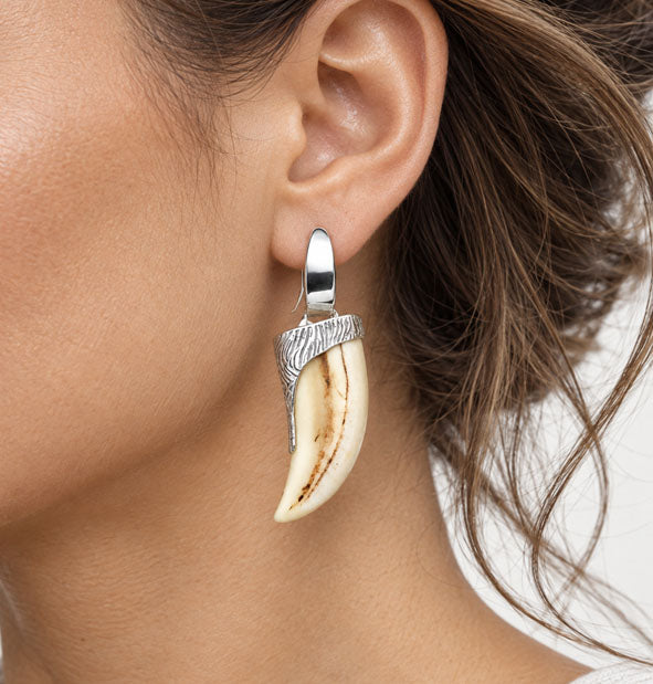 Pendientes Largos Colmillo Facochero Casquillo Tallado Plata 925  en la oreja de la modelo oreja izquierda