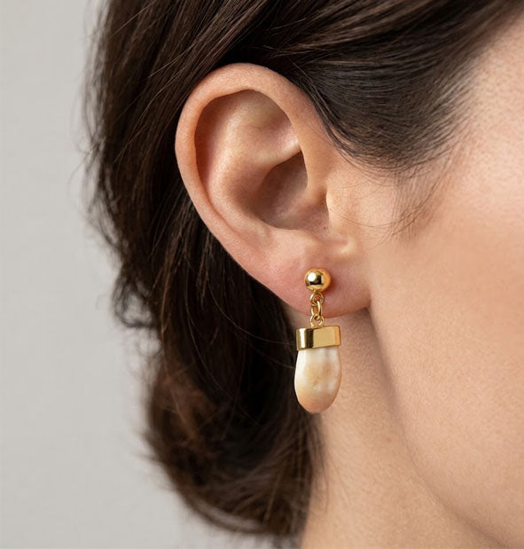 Pendientes Largos Bolita y Perla de Venado en Oro 18 Kilates en la oreja de la modelo