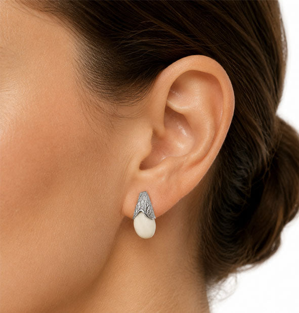 Pendiente Pequeño Campanita con Perla de Venado en Plata en la oreja de la modelo