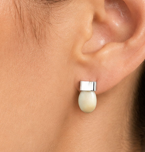 Pendiente Pequeño Liso con Perla de Venado en Plata detalle del pendiente en la oreja de la mujer