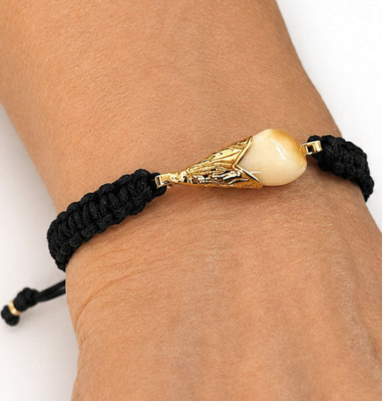 Pulsera Campanita Perla de Venado con Algodón y Oro 18 Kilates puesta en la muñeca