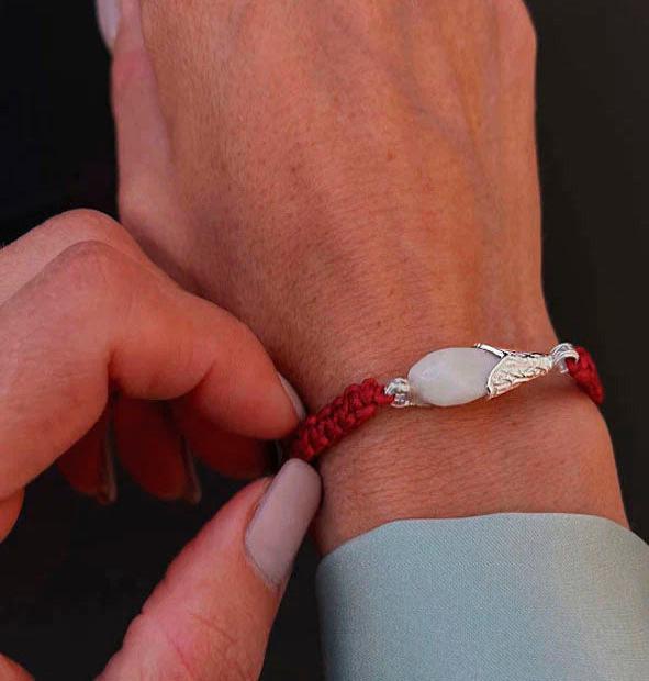 Pulsera artesanal de perla de venado con algodón negro y plata vista lateral diseño unisex hecho a mano