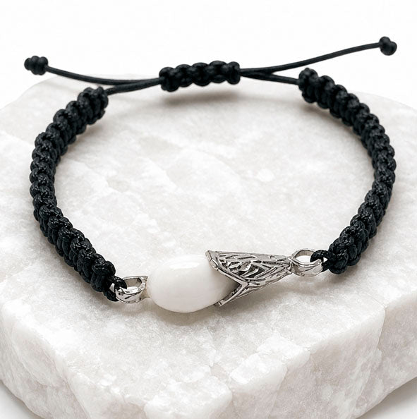 Detalle pulsera perla de venado con casquillo de plata y cordón de algodón negro trenzado ajustable
