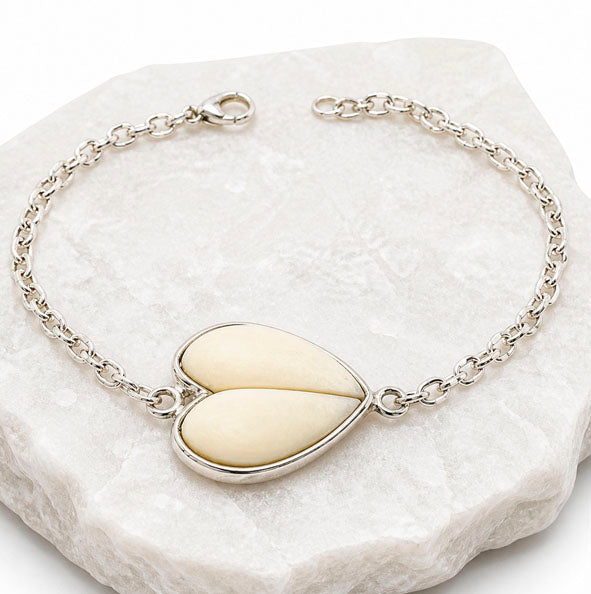 Detalle corazón formado por perlas de venado naturales en pulsera de plata de ley 925 diseño artesanal