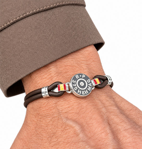 Pulsera de culata de bala con cuero y bandera de España detalle de lo personalizado con otro calibre en la mano del modelo