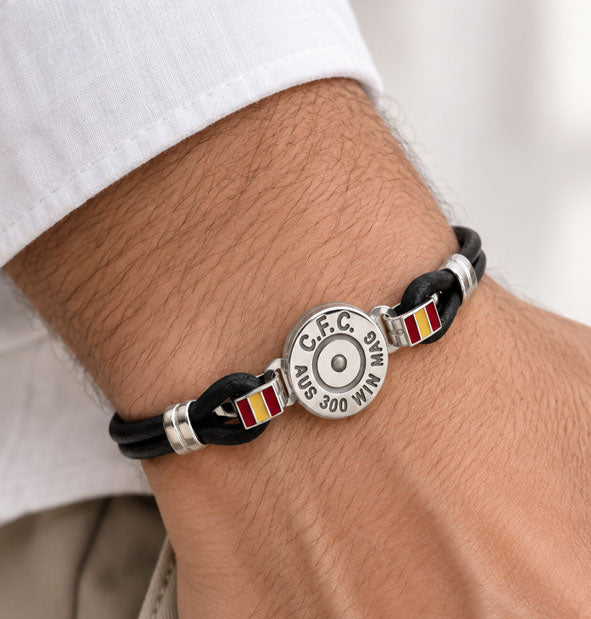 Pulsera de culata de bala con cuero y bandera de España detalle en la muñeca del modelo